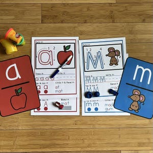 May include: Two printable worksheets for learning the letters 'a' and 'm'. Each worksheet includes a tracing activity, a tap and say activity, a blend it activity, and a circle it and read it activity. The 'a' worksheet features an apple and the 'm' worksheet features a mouse.