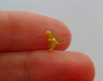 Cute and tiny irridescent yellow dinosaur figurine.
