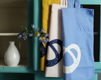 Pretzel shoulder bag made from 100% cotton – Hand-illustrated, ethically produced – Screen-printed design – Large 38 x 42 cm / Small 22 x 26 cm –