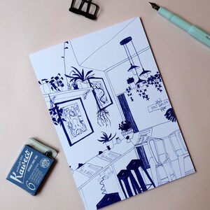May include: A blue and white line drawing of a cafe interior with hanging lights, plants, and tables. The text "EOTIVCE CYLE" is written on the wall.
