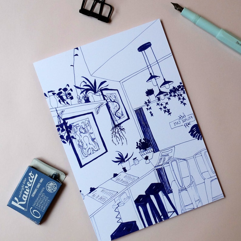 May include: A blue and white line drawing of a cafe interior with hanging lights, plants, and tables. The text "EOTIVCE CYLE" is written on the wall.