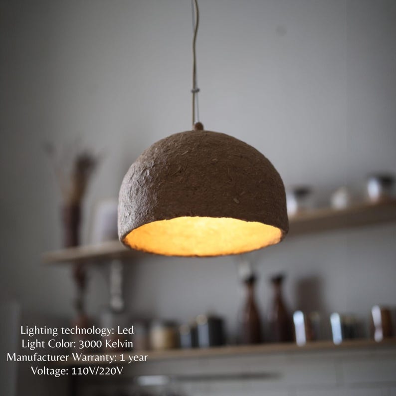 May include: A pendant light fixture with a brown, dome-shaped shade. The interior of the shade glows with a warm, yellow light. The fixture hangs from a thin cord. The text on the image says: Lighting technology: Led, Light Color: 3000 Kelvin, Manufacturer Warranty: 1 year, Voltage: 110V/220V.