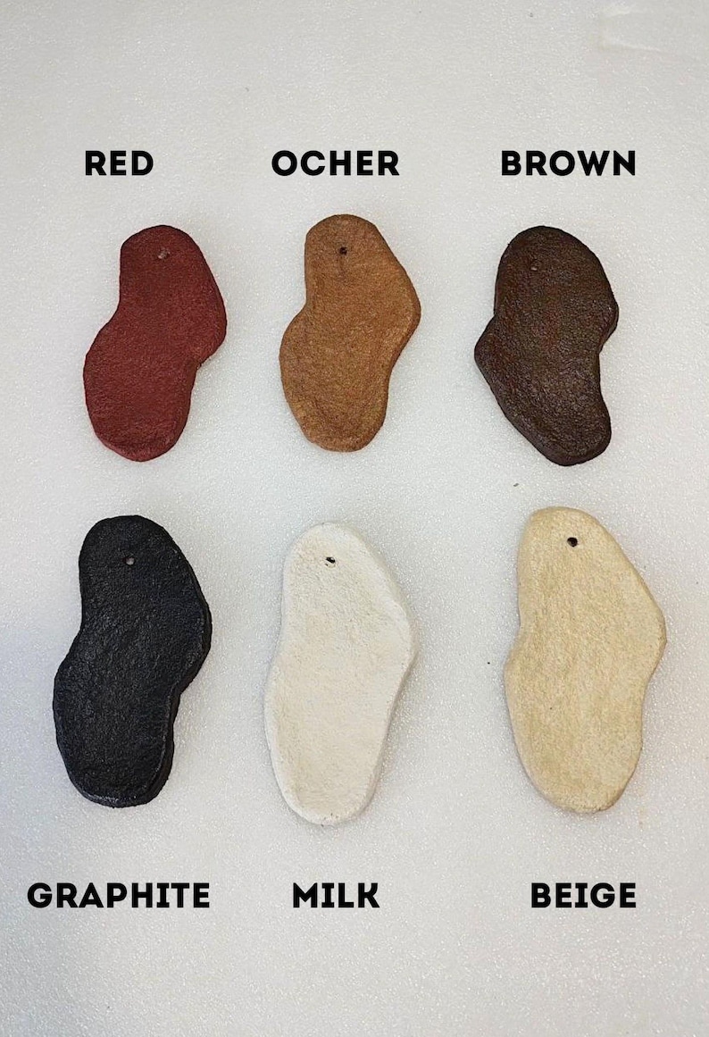 May include: Six irregularly shaped leather samples in different colors: red, ocher, brown, graphite, milk, and beige.
