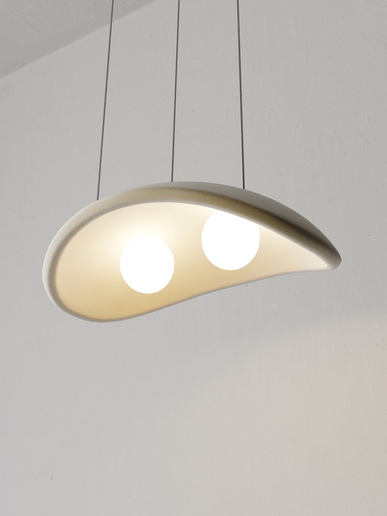 May include: A white, curved, pendant light fixture with two round, white light bulbs.