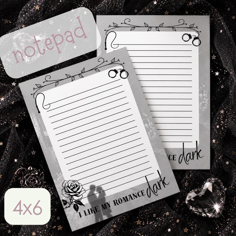 May include: Two rectangular 4x6 inch notepads with gray borders and white lined paper. The top features a vine illustration with handcuffs. The bottom displays a rose, a silhouette of a couple, and the text I LIKE MY ROMANCE dark.