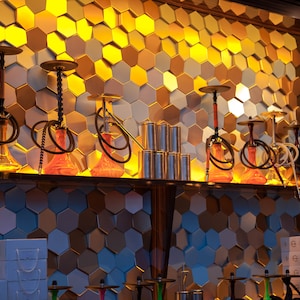 A boutique retail display wall featuring NORM 3D hexagonal panels as a textured background for showcasing products, providing a high-end, professional look.