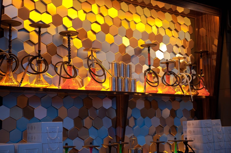 A boutique retail display wall featuring NORM 3D hexagonal panels as a textured background for showcasing products, providing a high-end, professional look.