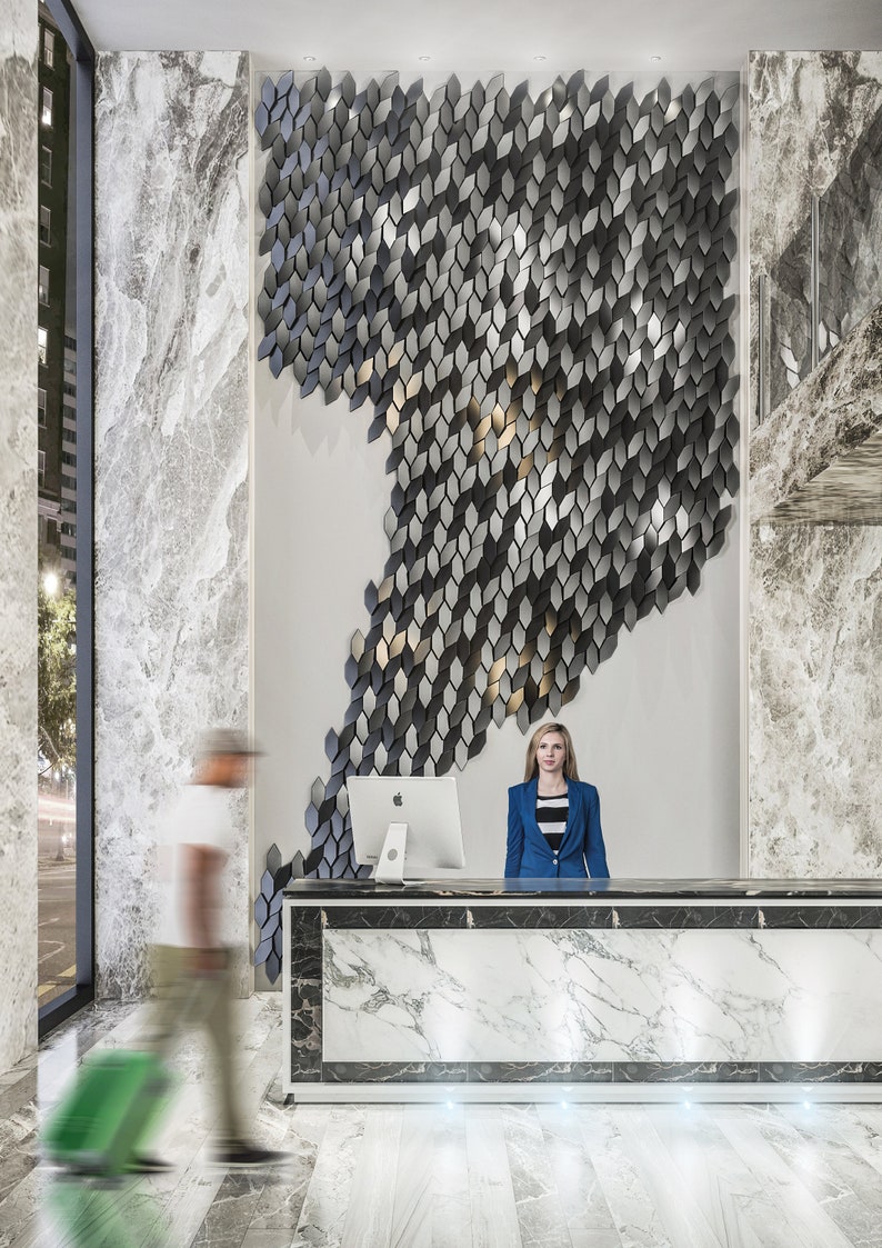 A sleek office reception area showcasing a contemporary waiting desk placed in front of a textured accent wall built with 3D Mabel copolymer tiles.