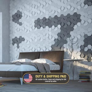 Pode incluir: Uma parede de quarto com um padr&atilde;o geom&eacute;trico tridimensional de azulejos hexagonais brancos e cinza-escuros. A parede serve de fundo para uma estrutura de cama castanho-escura com roupa de cama branca e uma pequena mesa de apoio.