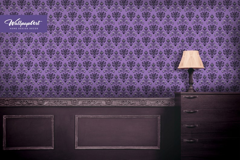 Puede incluir: Papel tapiz morado con un patr&oacute;n repetido de una cara de fantasma. El papel tapiz est&aacute; en una habitaci&oacute;n con molduras de madera oscura y una c&oacute;moda de madera oscura con una l&aacute;mpara en la parte superior.