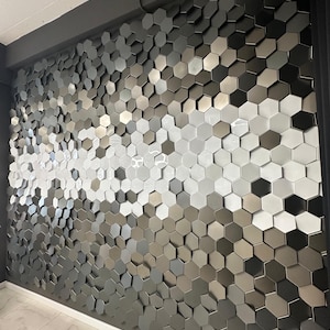 An angled view of the NORM 3D hexagon wall tiles showing the depth of the hexagonal relief and how they catch light to create subtle, soft shadows.