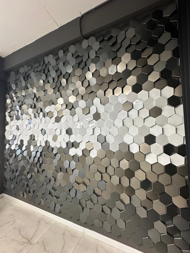 An angled view of the NORM 3D hexagon wall tiles showing the depth of the hexagonal relief and how they catch light to create subtle, soft shadows.