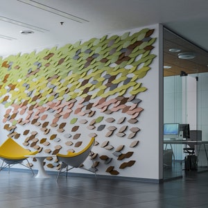 A modern office interior showcasing a textured accent wall built with MABEL geometric 3D copolymer wall panels.