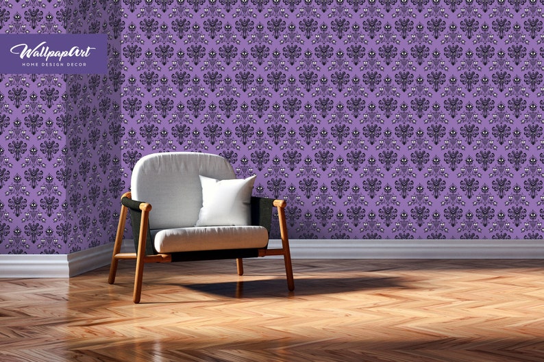 Puede incluir: Papel tapiz morado con un patr&oacute;n repetido de caras de fantasmas negros. Un sill&oacute;n blanco con marco negro se encuentra frente al papel tapiz.
