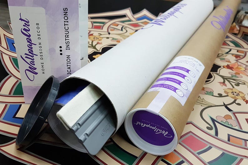 May include: A brown cardboard tube with a purple label that says "Wallpaper Art" and a white label with instructions for applying wallpaper. The tube is lying on a colorful patterned surface.