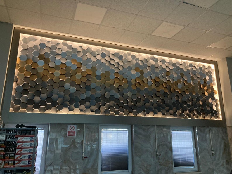 An installation shot showing how NORM 3D hexagonal wall panels seamlessly connect to form a continuous, cohesive geometric surface.