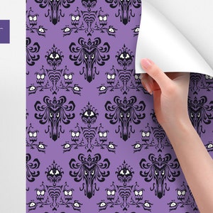 Puede incluir: Papel tapiz morado con un patr&oacute;n repetido de una mansi&oacute;n encantada negra con ojos blancos y un fantasma negro. El texto "WallpaperArt HOME DESIGN DECOR" est&aacute; en la esquina superior izquierda.