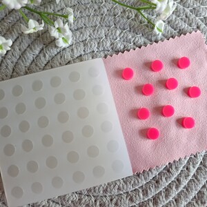 May include: A white silicone mould with 42 round impressions and a pink felt sheet with 10 pink round dots.