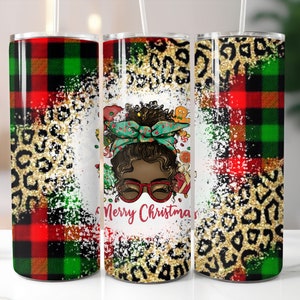Könnte beinhalten: Drei Edelstahlbecher mit Weihnachtsmotiv. Die Becher zeigen ein rot-grünes Karomuster, einen goldenen Leopardenprint und einen weißen Hintergrund mit einer Cartoon-Illustration eines schwarzen Mädchens mit grünem Stirnband und roten Brillen. Der Text "Merry Christmas" ist in Rot auf dem weißen Hintergrund geschrieben.