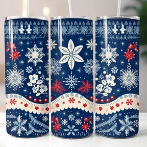 May include: Three stainless steel tumblers with a blue background and a wintery pattern of snowflakes, pine branches, and red berries. The tumblers are decorated with a white scalloped border and red dots.