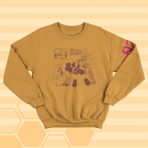 May include: A mustard yellow sweatshirt with a pink and purple graphic print of a cartoon character. The graphic includes the text "Rin Loves".