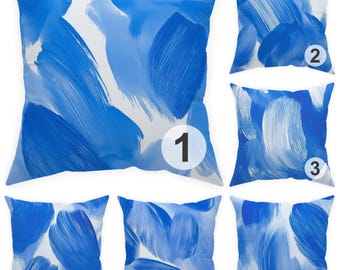 May include: Six square cushions with a white background and a bold blue brushstroke design. The cushions feature a variety of abstract patterns, with each cushion showcasing a unique arrangement of the blue strokes. The cushions are numbered 1 through 6.