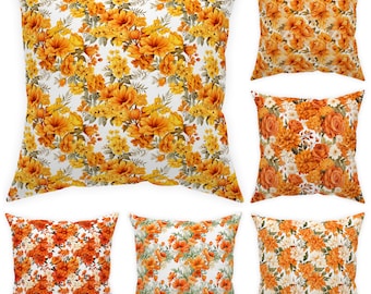 Op de afbeelding: Zes decoratieve kussens met een bloemenpatroon. De kussens hebben een witte achtergrond met oranje en gele bloemen.