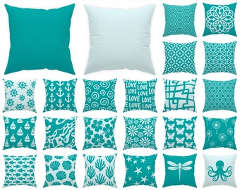 Pode incluir: Uma coleção de 20 almofadas decorativas com vários designs e cores. As almofadas incluem cores sólidas turquesa, branco e padrões como âncoras, conchas e motivos florais. O texto na parte superior diz "Swipe to see all 70 pillows!" e na parte inferior "Each pillow is numbered for easy selection."