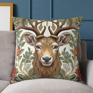 Pode incluir: Uma almofada decorativa com uma ilustração de um veado castanho e branco rodeado por desenhos florais verdes e laranja.