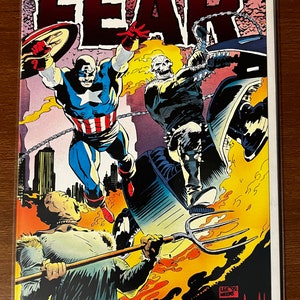 May include: A comic book cover featuring Ghost Rider and Captain America. The cover is titled "FEAR" and features a fiery background with the two superheroes in action. The cover is in good condition with some minor wear and tear.