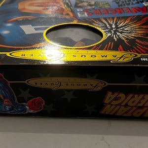 May include: A black box featuring Captain America artwork and the text "Famous Cover". The box has a clear window and the words "First Appearances" are visible. The Marvel Comics logo is also present.