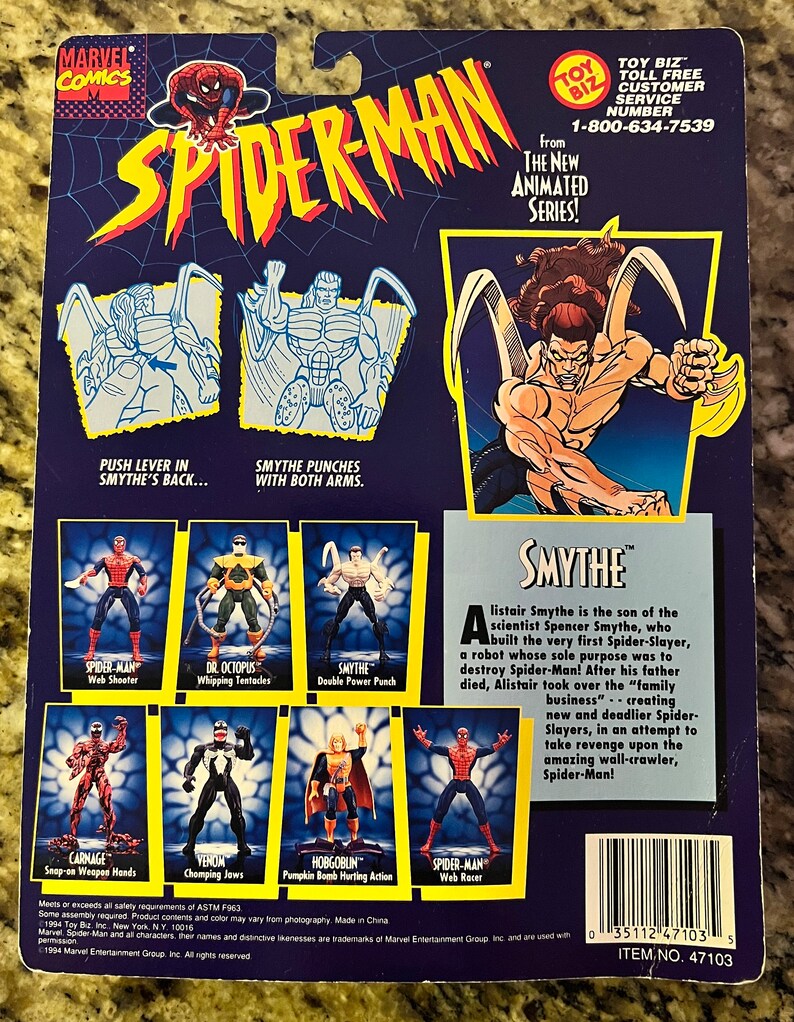 May include: A plastic action figure of Spider-Man's nemesis, Smythe, from the animated series. The figure is red and black with a yellow spider symbol on the chest. The figure is posed in a fighting stance with its arms outstretched. The figure is packaged on a blue and white card with a picture of Smythe on the back. The card also includes a description of Smythe's character and a list of other Spider-Man action figures.