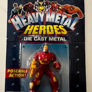 Pode incluir: Figura de a&ccedil;&atilde;o de metal fundido "Heavy Metal Heroes" do Homem de Ferro. A figura &eacute; vermelha e dourada, com a&ccedil;&atilde;o articulada. A embalagem apresenta a marca Marvel Comics e imagens de outros her&oacute;is. A embalagem inclui um aviso de perigo de asfixia.