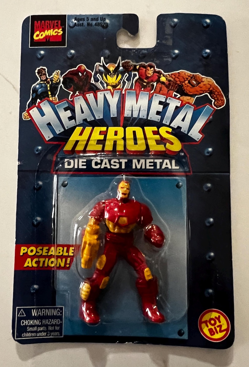 Pode incluir: Figura de a&ccedil;&atilde;o de metal fundido "Heavy Metal Heroes" do Homem de Ferro. A figura &eacute; vermelha e dourada, com a&ccedil;&atilde;o articulada. A embalagem apresenta a marca Marvel Comics e imagens de outros her&oacute;is. A embalagem inclui um aviso de perigo de asfixia.