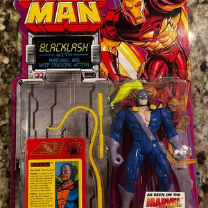 May include: Iron Man Blacklash action figure in original packaging. The figure is blue, purple, and yellow, with a cape and whip. The packaging features the Marvel Comics logo and the text "Blacklash with Nunchaku and Whip Cracking Action."