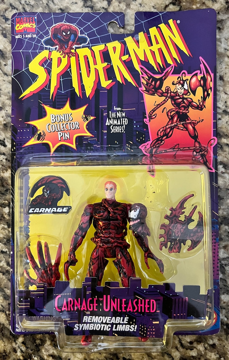 May include: Carnage: Unleashed action figure from the Spider-Man animated series. The figure is red and black with removable limbs. The packaging features a bonus collector pin.