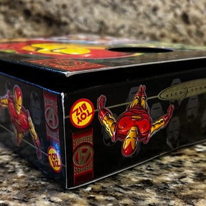 May include: A black box with a red and yellow Iron Man figure on the side. The box has the words "Iron Man" and "Toy Biz" on it.