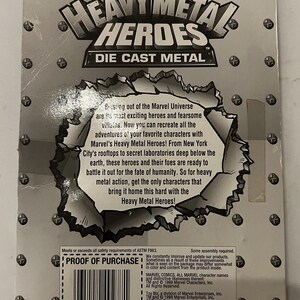 May include: The reverse of a Heavy Metal Heroes die-cast metal toy package. The package features the Marvel Comics logo and the text "Heavy Metal Heroes" in a silver, metallic font. The text describes the characters and their adventures.