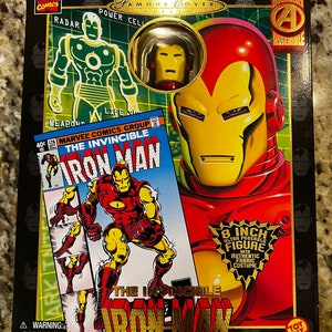 May include: A red and gold Iron Man action figure with a comic book cover featuring the text "The Invincible Iron Man". The figure is 8 inches tall and has an authentic fabric costume. The box is black with gold accents and features the Marvel Comics logo.