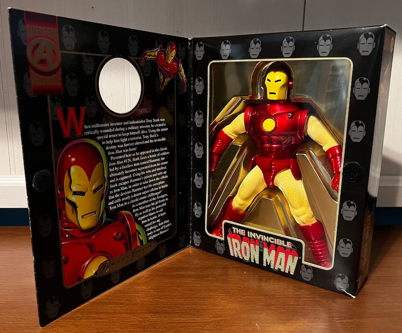 May include: A red and yellow action figure of Iron Man, the Invincible, in a box with a black background and a gold border. The box has a picture of Iron Man on the front and the words "The Invincible Iron Man" on the bottom.