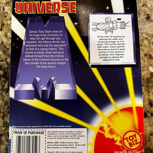 Puede incluir: La parte posterior de una caja de cart&oacute;n para una figura de acci&oacute;n de Iron Man de Marvel Universe. La caja es azul, amarilla y roja con una imagen de la armadura Inferno de Iron Man. El texto de la caja dice "Marvel Universe" e "Iron Man".