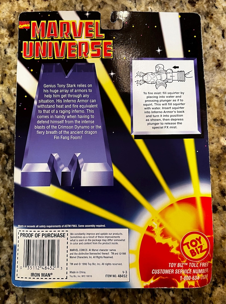 Puede incluir: La parte posterior de una caja de cart&oacute;n para una figura de acci&oacute;n de Iron Man de Marvel Universe. La caja es azul, amarilla y roja con una imagen de la armadura Inferno de Iron Man. El texto de la caja dice "Marvel Universe" e "Iron Man".