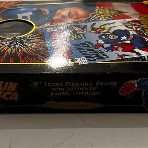 May include: A black box featuring Captain America graphics, including comic book art and the character's image. The box reads "CAPTAIN AMERICA" and "8" Ultra Poseable Figure with Authentic Fabric Costume!"