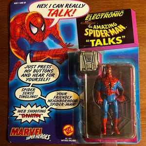 K&ouml;nnte beinhalten: Elektronische Amazing Spider-Man-Actionfigur in Originalverpackung. Die Verpackung zeigt eine Comic-Illustration von Spider-Man und den Text "Hey, I can really talk!" und "Your friendly neighborhood Spider-Man!"