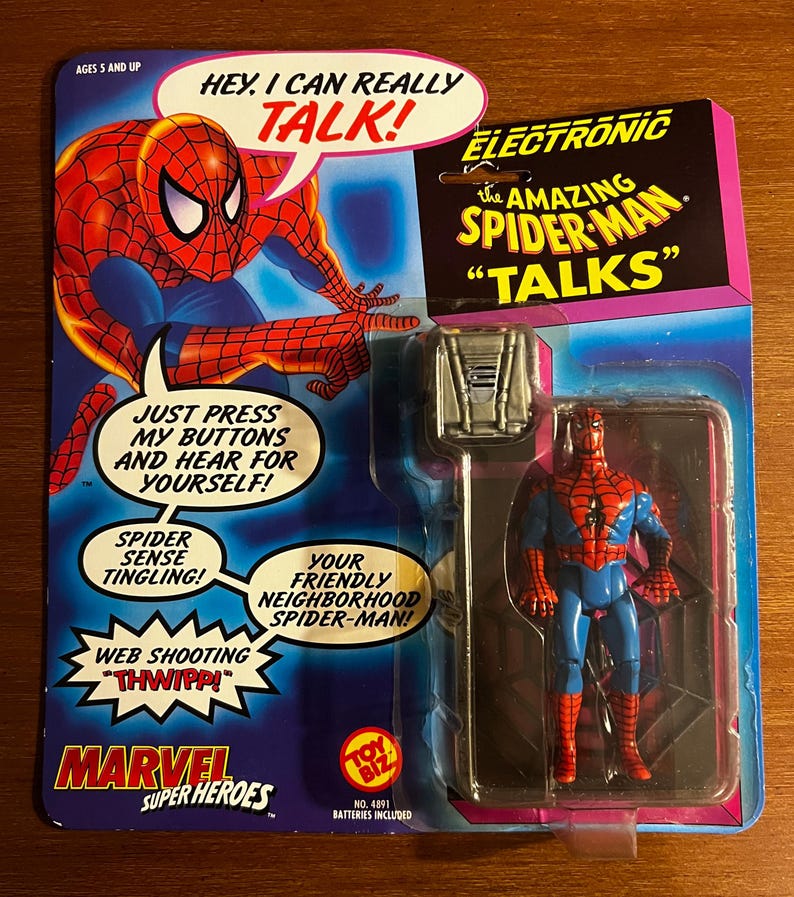 K&ouml;nnte beinhalten: Elektronische Amazing Spider-Man-Actionfigur in Originalverpackung. Die Verpackung zeigt eine Comic-Illustration von Spider-Man und den Text "Hey, I can really talk!" und "Your friendly neighborhood Spider-Man!"