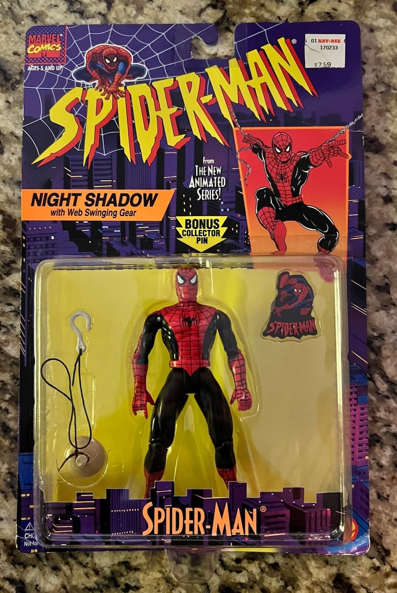 May include: A red and black Spider-Man action figure with web-swinging gear. The figure is packaged in a plastic blister pack with a yellow background. The packaging features the words "Spider-Man" and "Night Shadow" in large, bold letters. The packaging also includes a bonus collector pin.