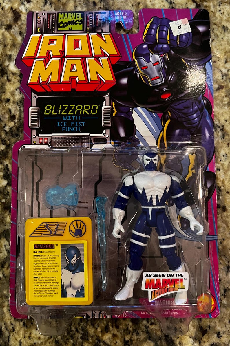 K&ouml;nnte beinhalten: Eine blaue und wei&szlig;e Actionfigur von Blizzard, einem Marvel Comics-Charakter, mit einem Eisfaust-Schlag. Die Figur ist in einer Plastik-Blisterverpackung mit einer gelben und schwarzen Karte verpackt, die den Namen des Charakters, seine Kr&auml;fte und sein Profil zeigt. Die Karte enth&auml;lt auch ein kleines Bild des Charakters. Die Verpackung zeigt auch ein rotes und gelbes Marvel Action Hour-Logo.