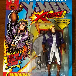 Può includere: Una action figure di plastica di Cannonball della serie di fumetti X-Force. La figura indossa un costume viola e bianco con una cintura marrone e stivali marroni. La figura tiene uno zaino lanciacatapulta argentato e grigio. La figura è confezionata in una confezione blister di plastica con un retro in cartone blu e bianco. Il retro presenta il logo Marvel Comics, il logo X-Force e il testo "The Uncanny X-Men".