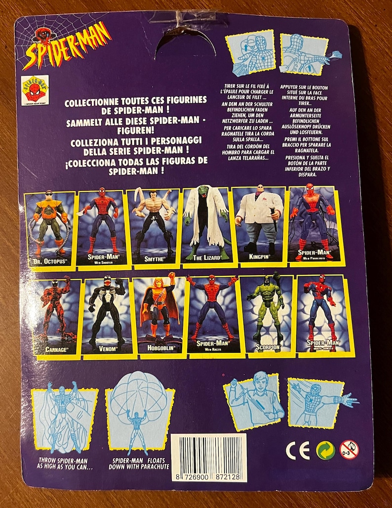 May include: A colorful card back for a Spider-Man action figure toy. The card features a variety of Spider-Man characters, including Dr. Octopus, Venom, and Carnage. The card also includes instructions on how to play with the figure, such as how to launch the web shooter and how to make the figure float with a parachute.