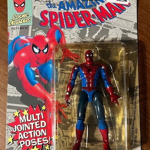 May include: A red and blue plastic action figure of Spider-Man with multi-jointed limbs. The figure is packaged in a plastic blister pack with a cardboard backing. The packaging features a comic book style image of Spider-Man and the text "The Amazing Spider-Man".